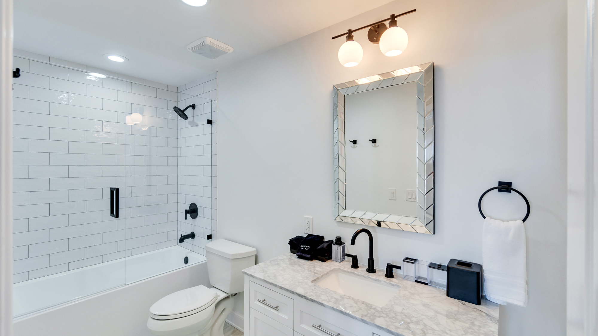 White bathroom with silver fixtures with bathtub and shower at the Sea Palms Estate in Captiva Island, FL